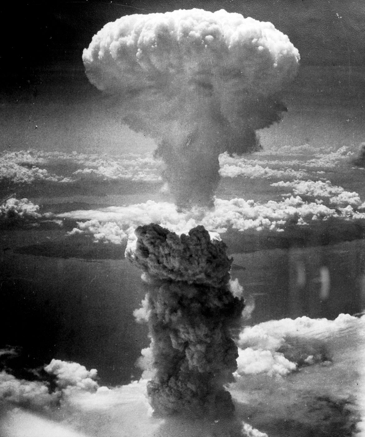 雲の上に、きのこのような形の白いけむりの雲が高くのぼっている白黒の写真