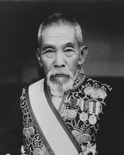 白いあごひげをはやし、もようのある礼服に勲章をつけた、年配の男性