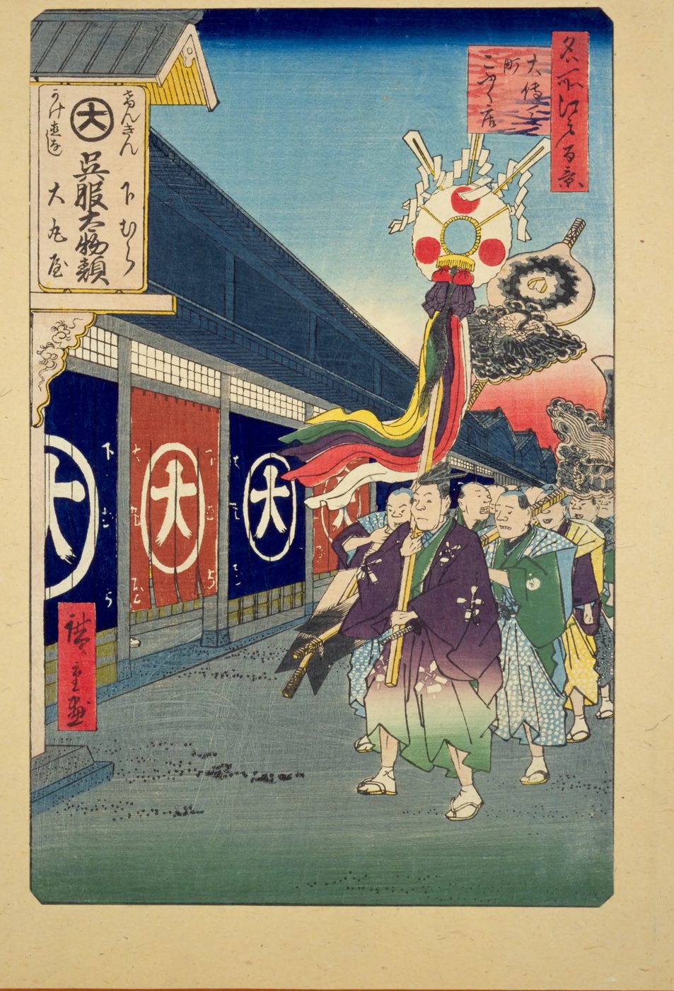 大きな「大」の字ののれんが下がった店の前を、かざりのついた長い棒を持った人たちが行列して歩く浮世絵