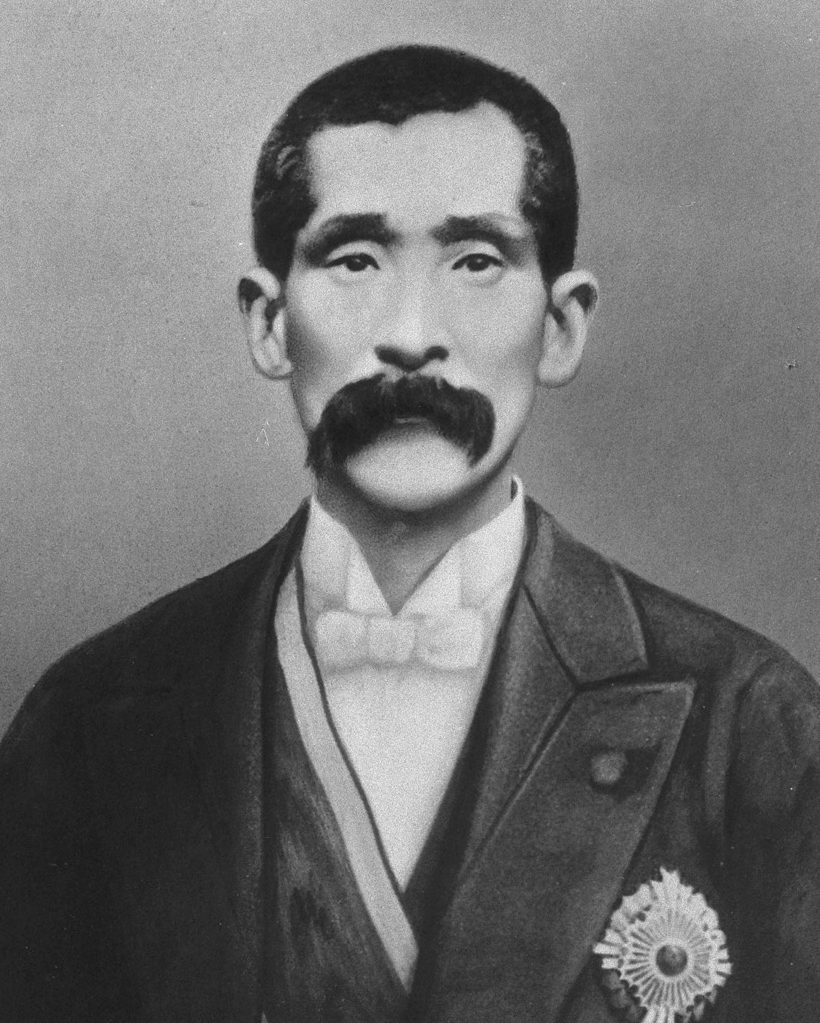 こい口ひげをはやし、洋服に勲章をつけた男性の写真
