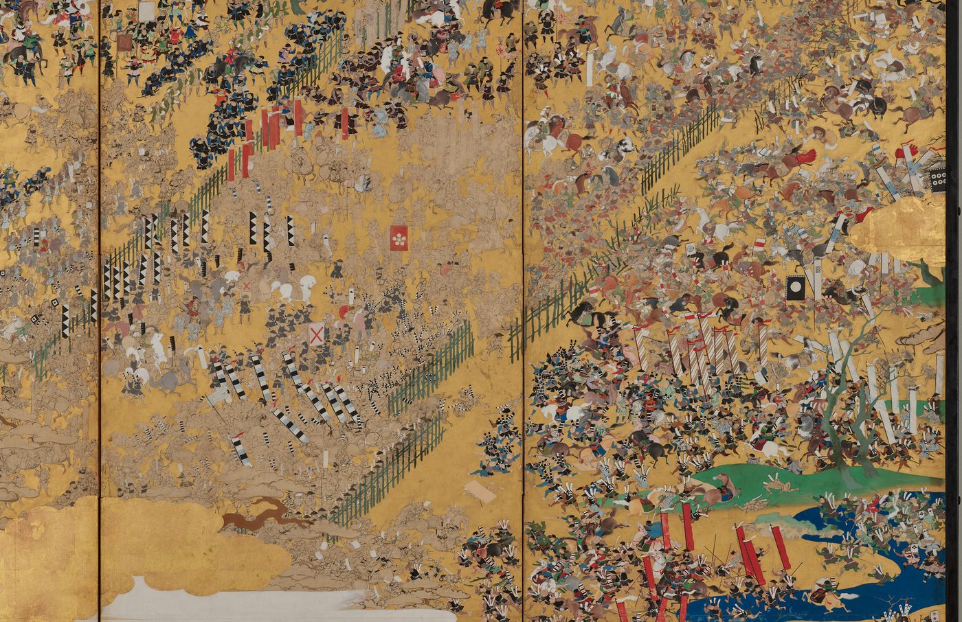金色の背景に、柵の内側と外側で、たくさんの武士や馬が入り乱れる戦いの場面をえがいた屏風
