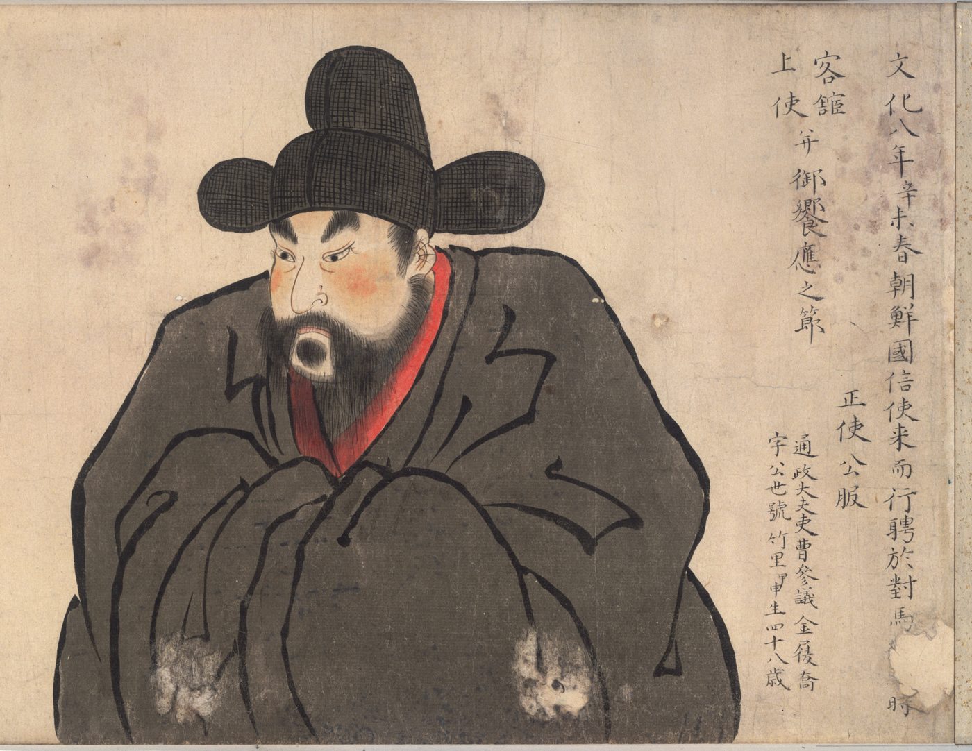 黒い帽子をかぶり、黒い服を着た、ひげのある男性の絵。右に文字が書かれている