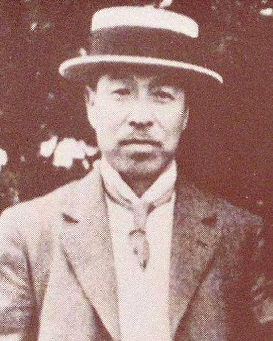 かんかん帽をかぶり、洋服を着た男性の顔と上半身